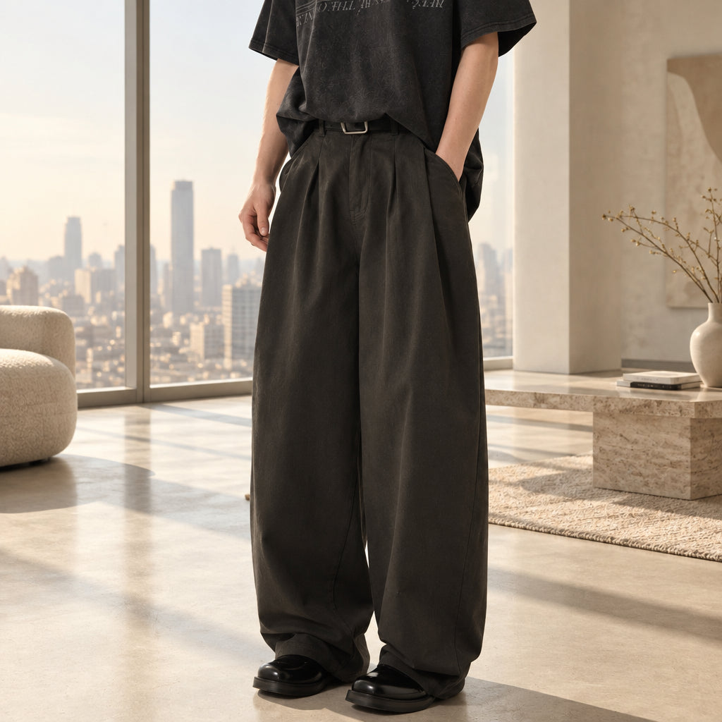 Dark washed pleated wide-leg trousers with gathered waistband and relaxed fit.