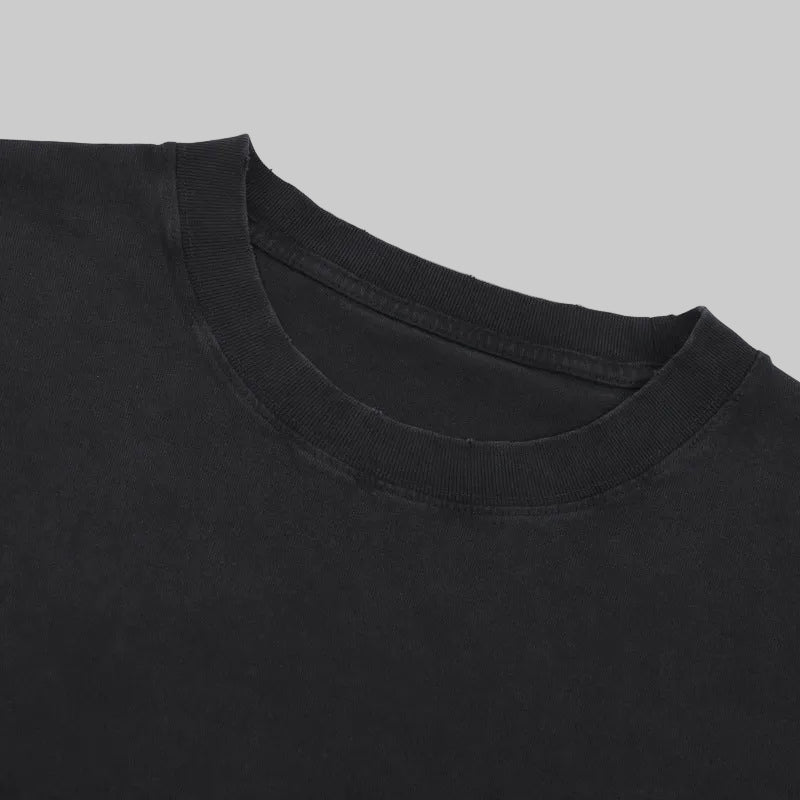 Distressed crew-neck tee close-up in black, ribbed collar, short sleeves.