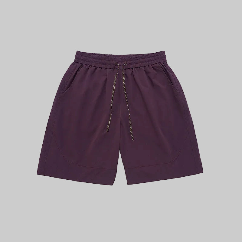 Purple technical training shorts with elastic waistband, drawstring, and side pockets.