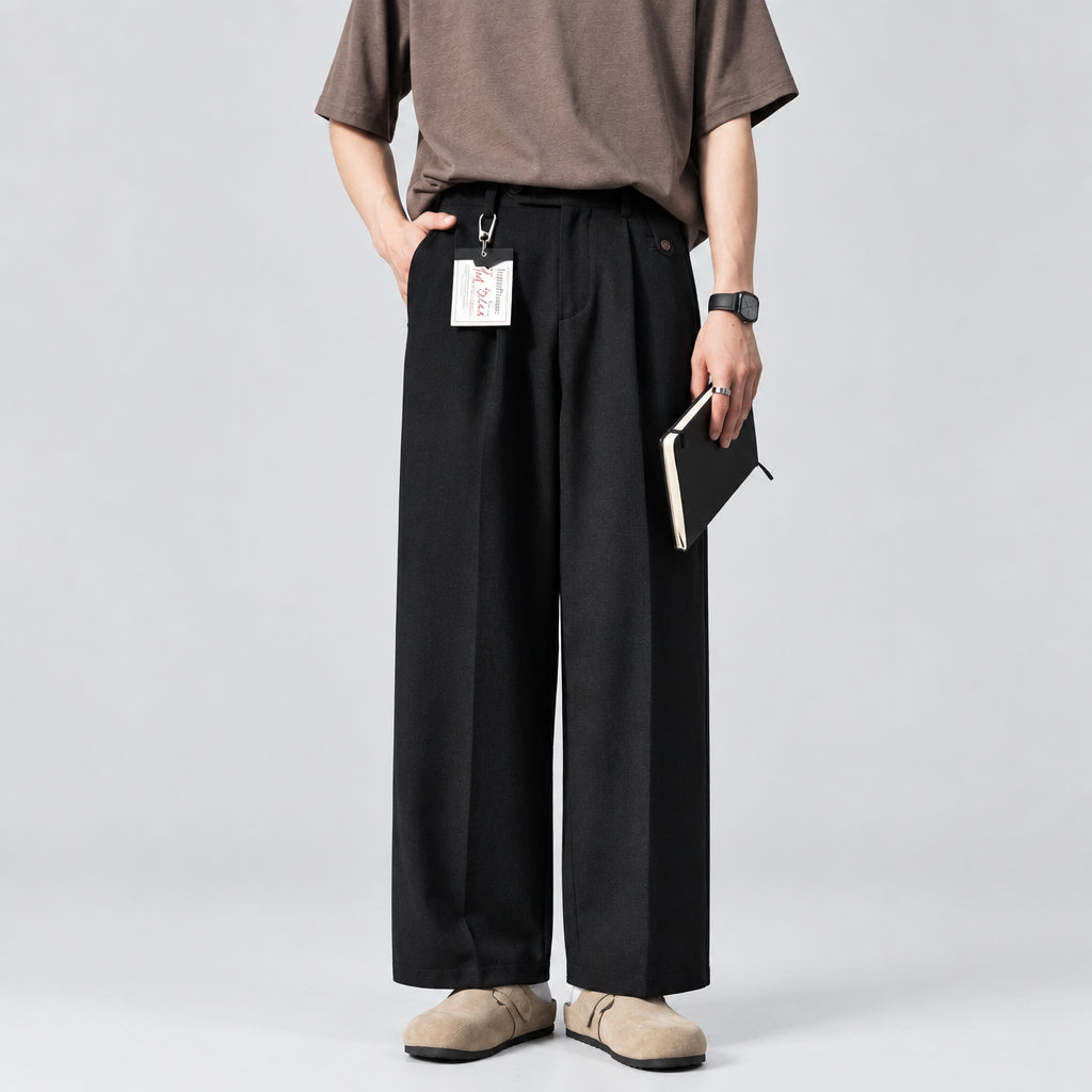 Pleated drape trousers in black with relaxed wide-leg fit, pleats, and belt loops.
