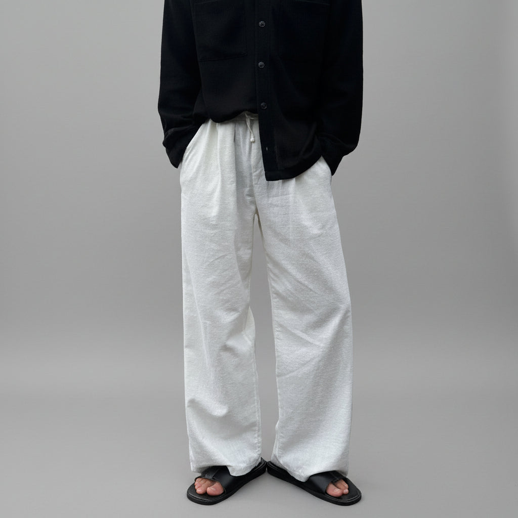 Ivory linen wide-leg trousers with elastic waistband and flowing straight legs