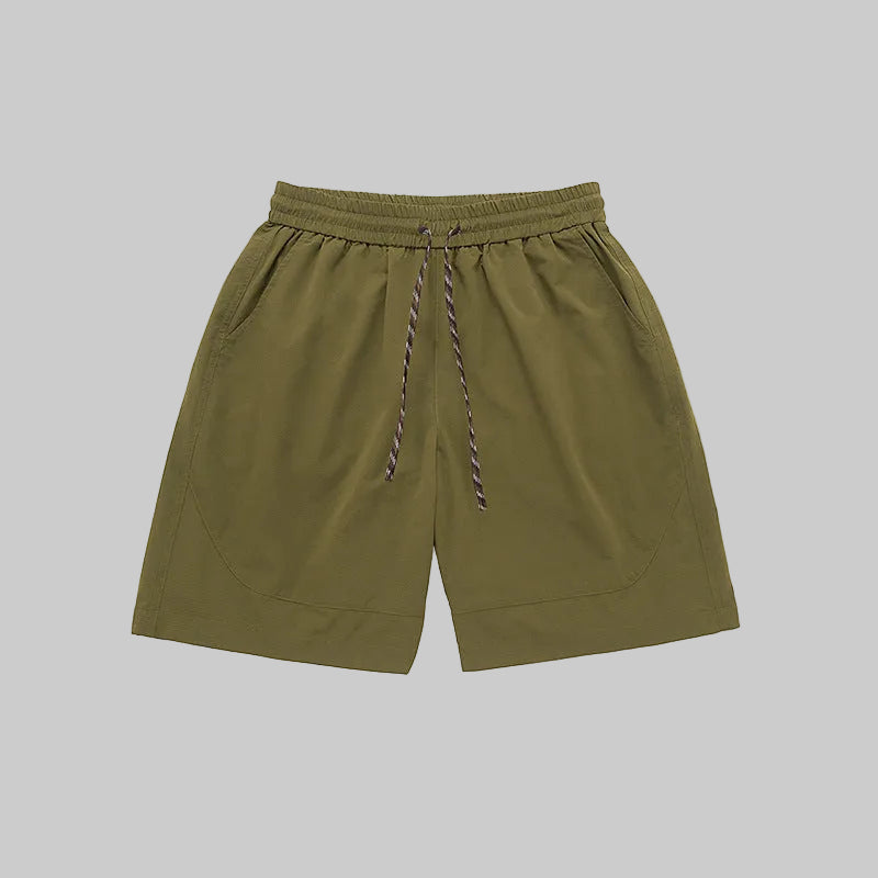 Olive technical training shorts with elastic waistband, drawstring, and side pockets.