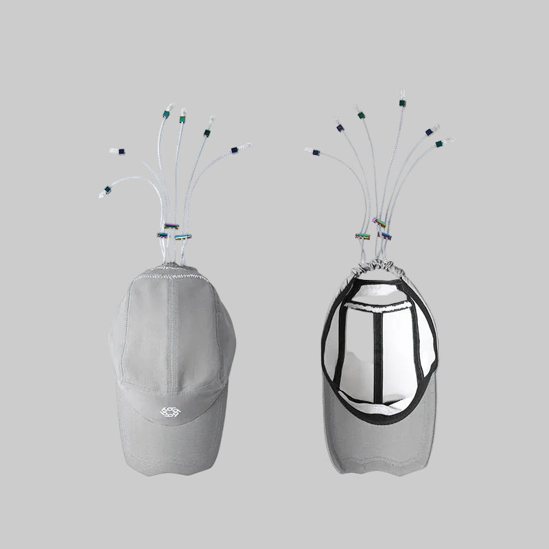 Two light gray caps hanging with multicolor cords, one showing dark reflective panel