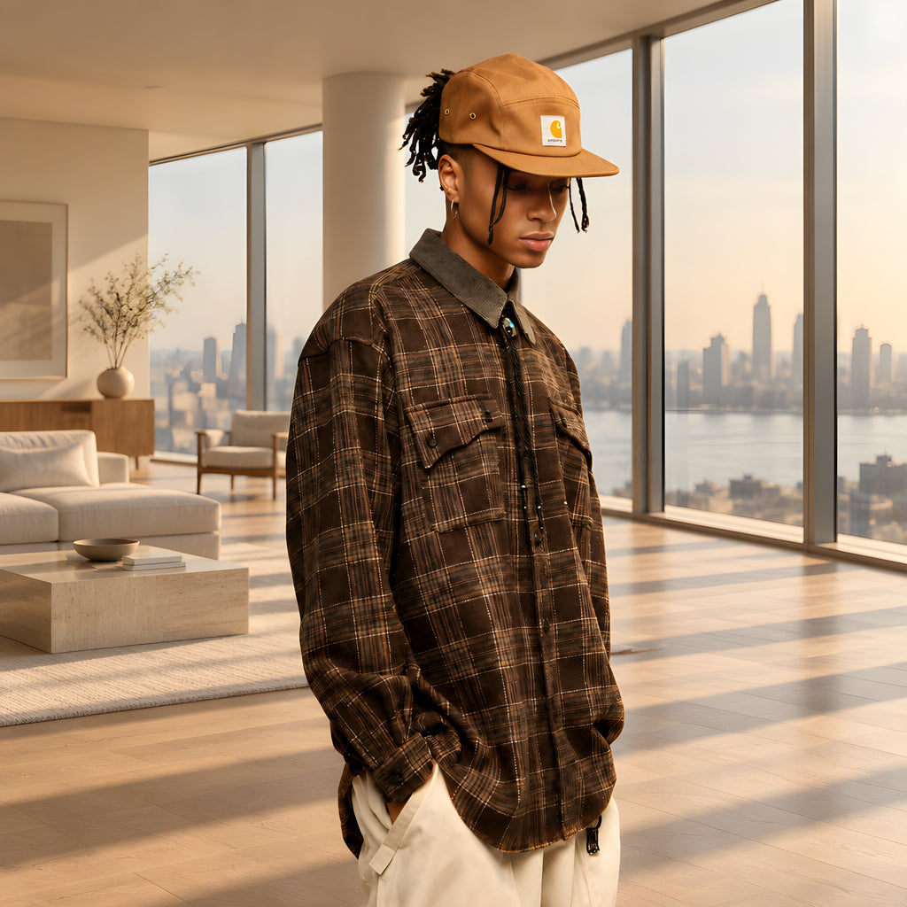 Espresso plaid overshirt on model, with long sleeves, flap chest pockets, and button cuffs