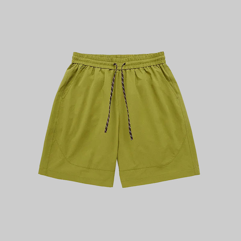 Lime technical training shorts with elastic waistband, drawstring, and side pockets.