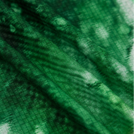 Close-up of deep green woven fabric with subtle texture and soft sheen