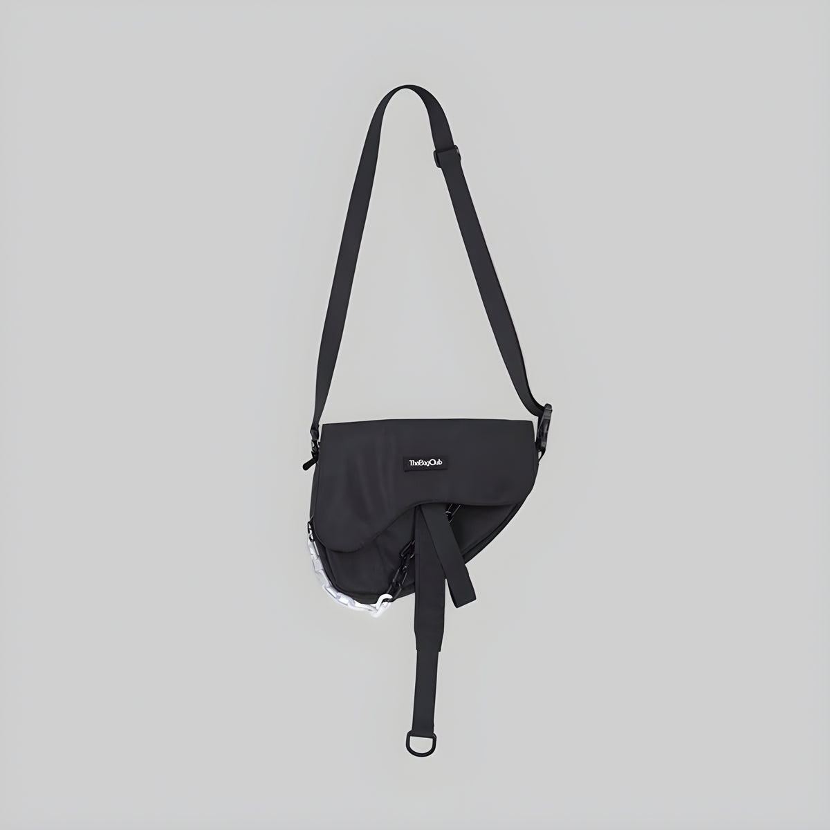 Black single-strap crossbody sling bag with front flap and hanging tie detail