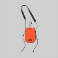 Orange mini drawcord pouch with black adjustable crossbody straps and drawstring top.