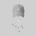 Light gray photochromic cap with front logo and dangling white cords with multicolor tips