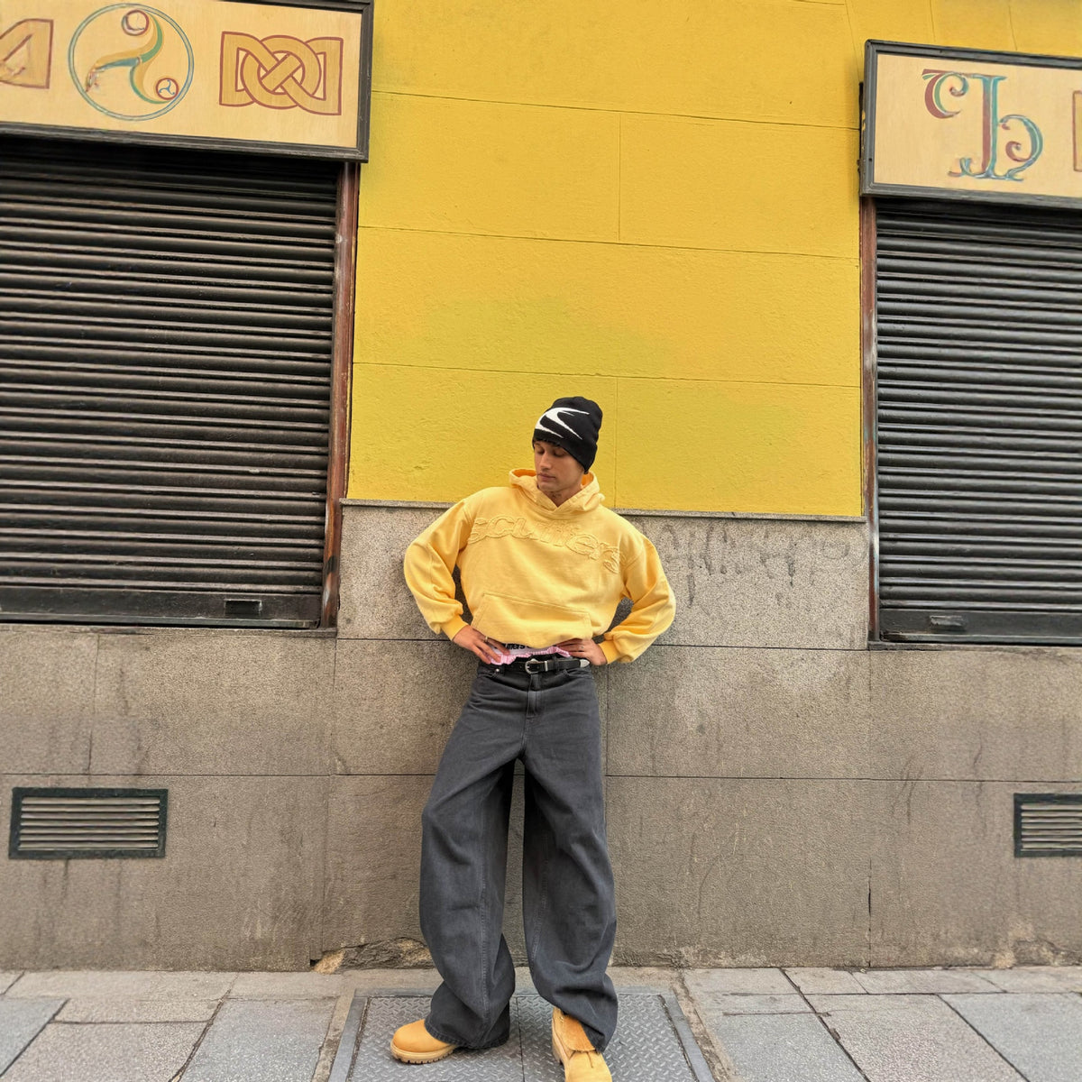 Ochre pullover hoodie with hood, front pocket, and embossed lettermark on the chest