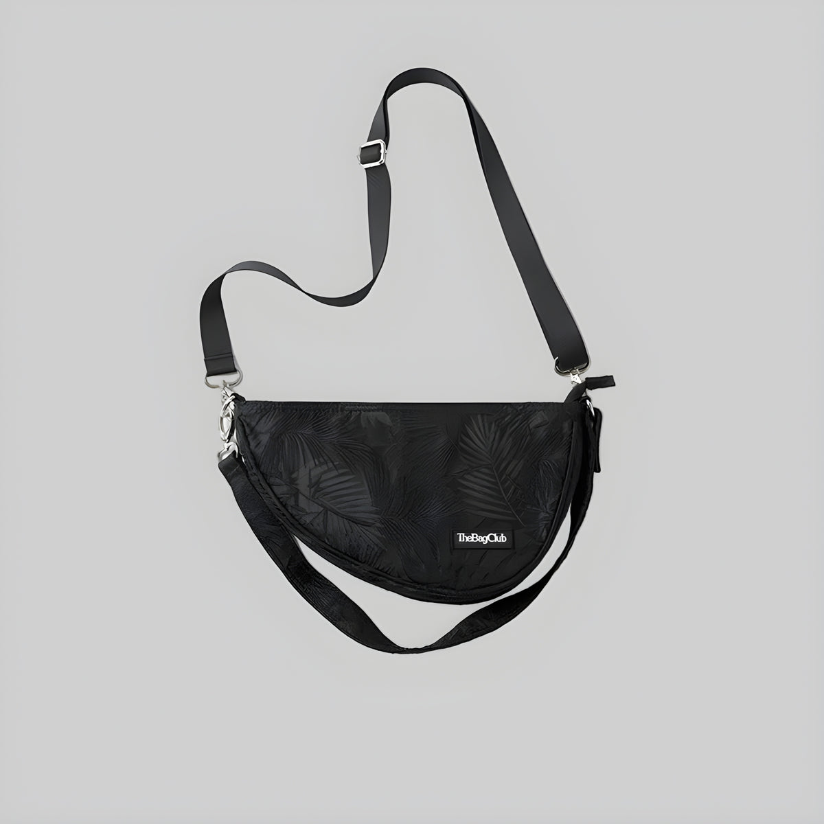 Black crescent sling bag with adjustable shoulder strap and front logo patch