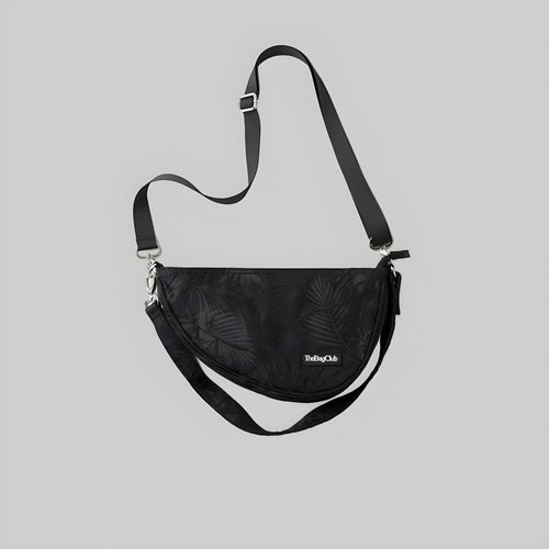 Black crescent sling bag with adjustable shoulder strap and front logo patch