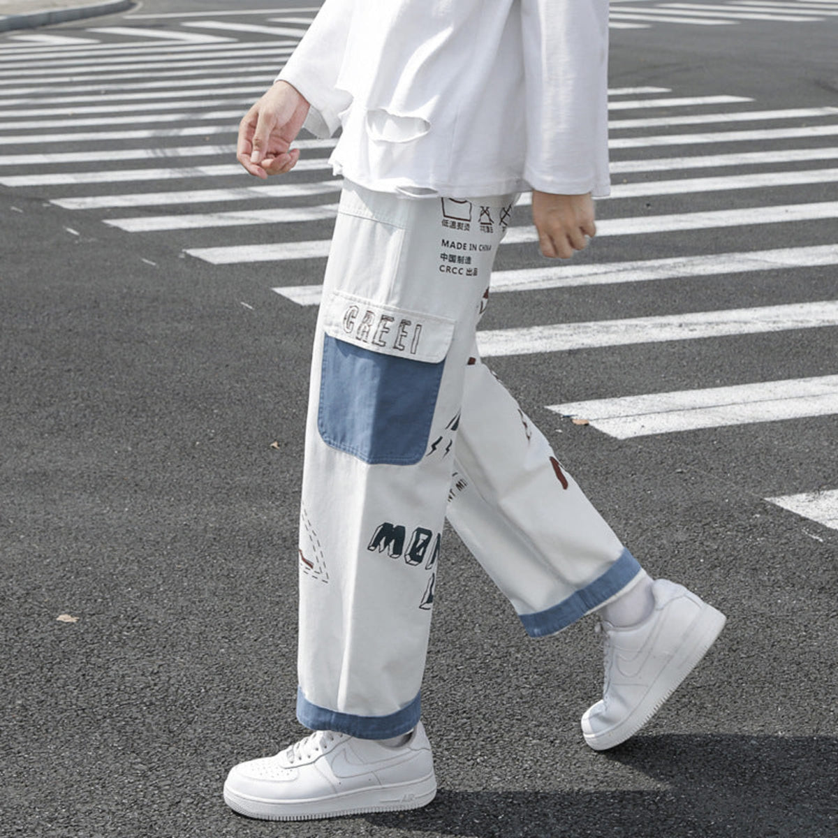 Ivory graffiti washed jeans, side view with blue-edged patch pocket and graphic text print