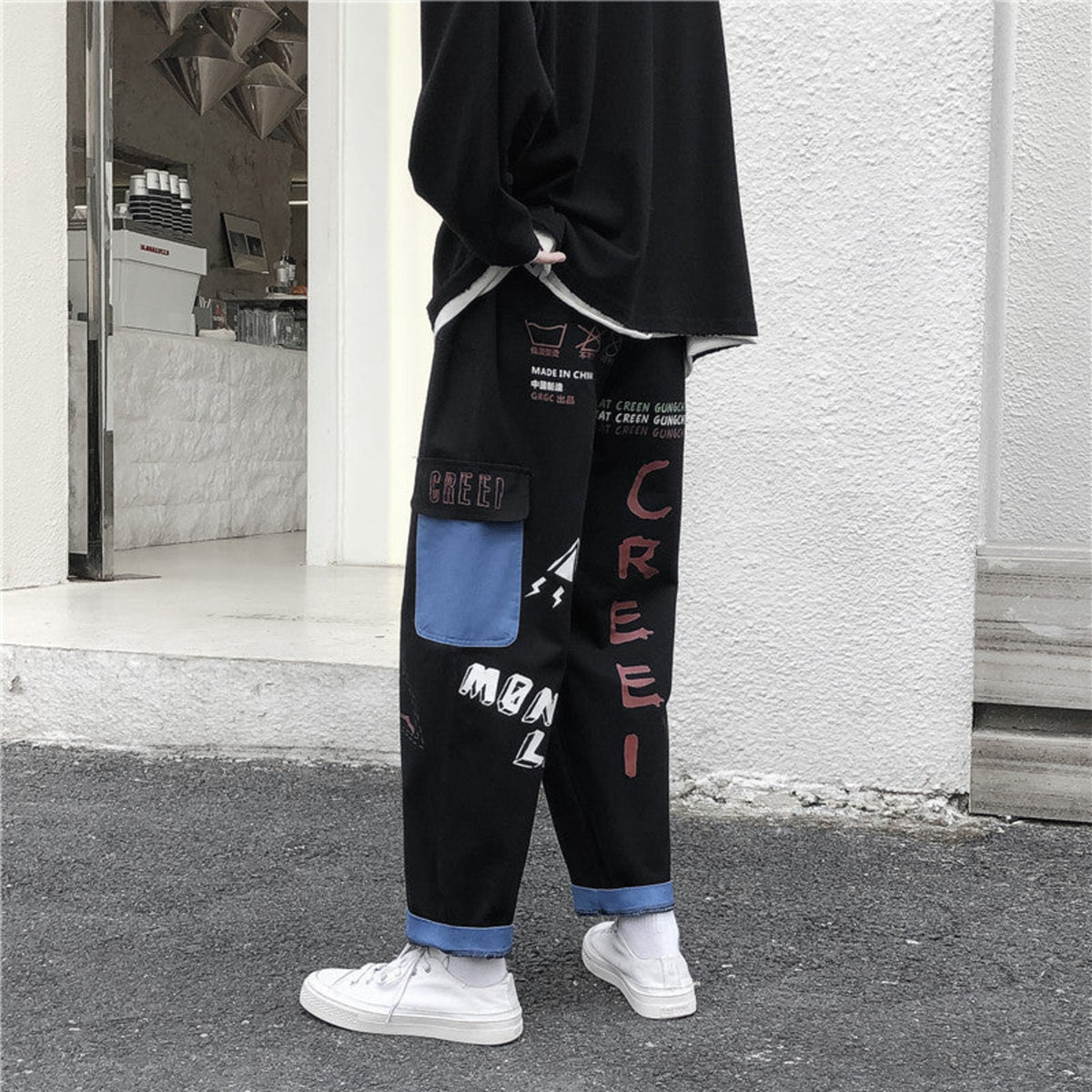Black graffiti washed jeans with blue cuff trim, panel pockets and red/white graphic text