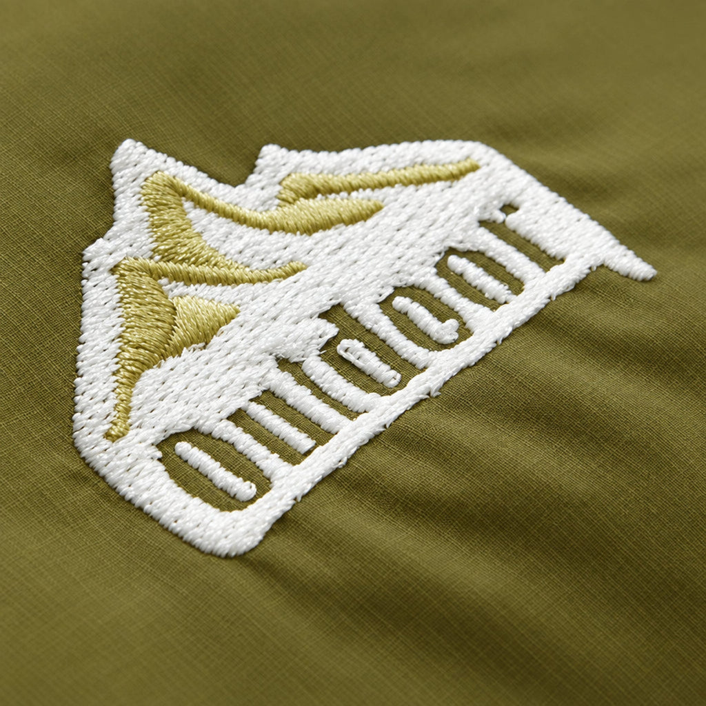 Embroidered logo patch on green fabric